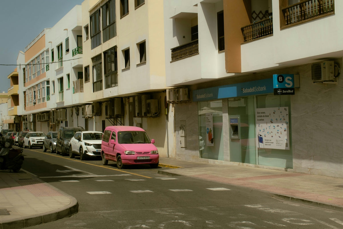 a pink car parked on the side of a street
